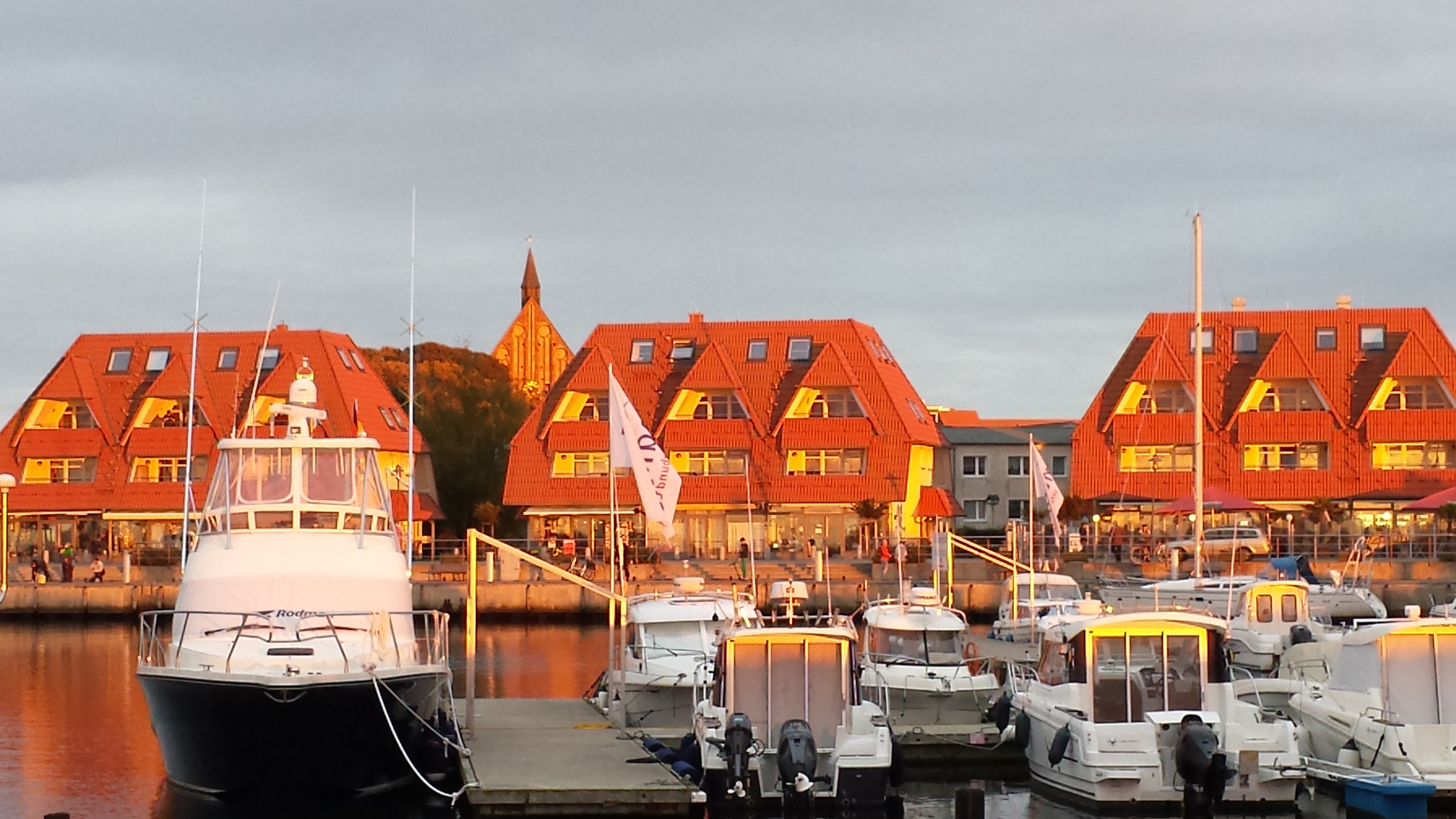 Wieker Hafen mit Geschäfte und Anlegestelle für Fahrgastschiffe z. B. nach Hiddensee, ca. 800 m vom Ferienhaus entfernt. Im Hintergrund die Kirche im Zentrum des Ortes
